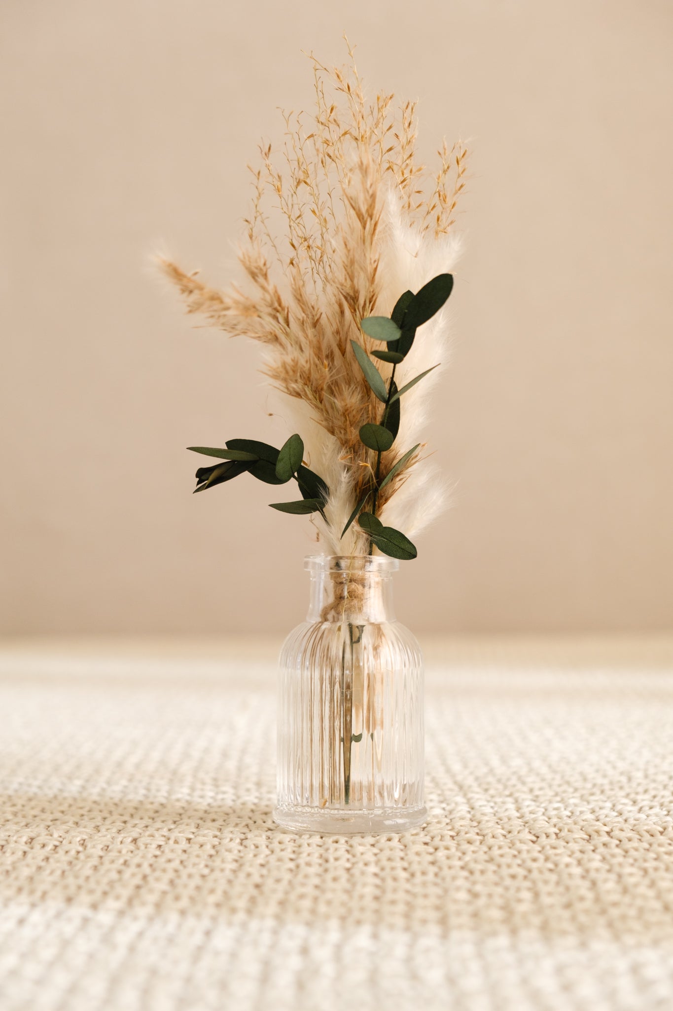 Fiole avec bouquet de fleurs séchées
