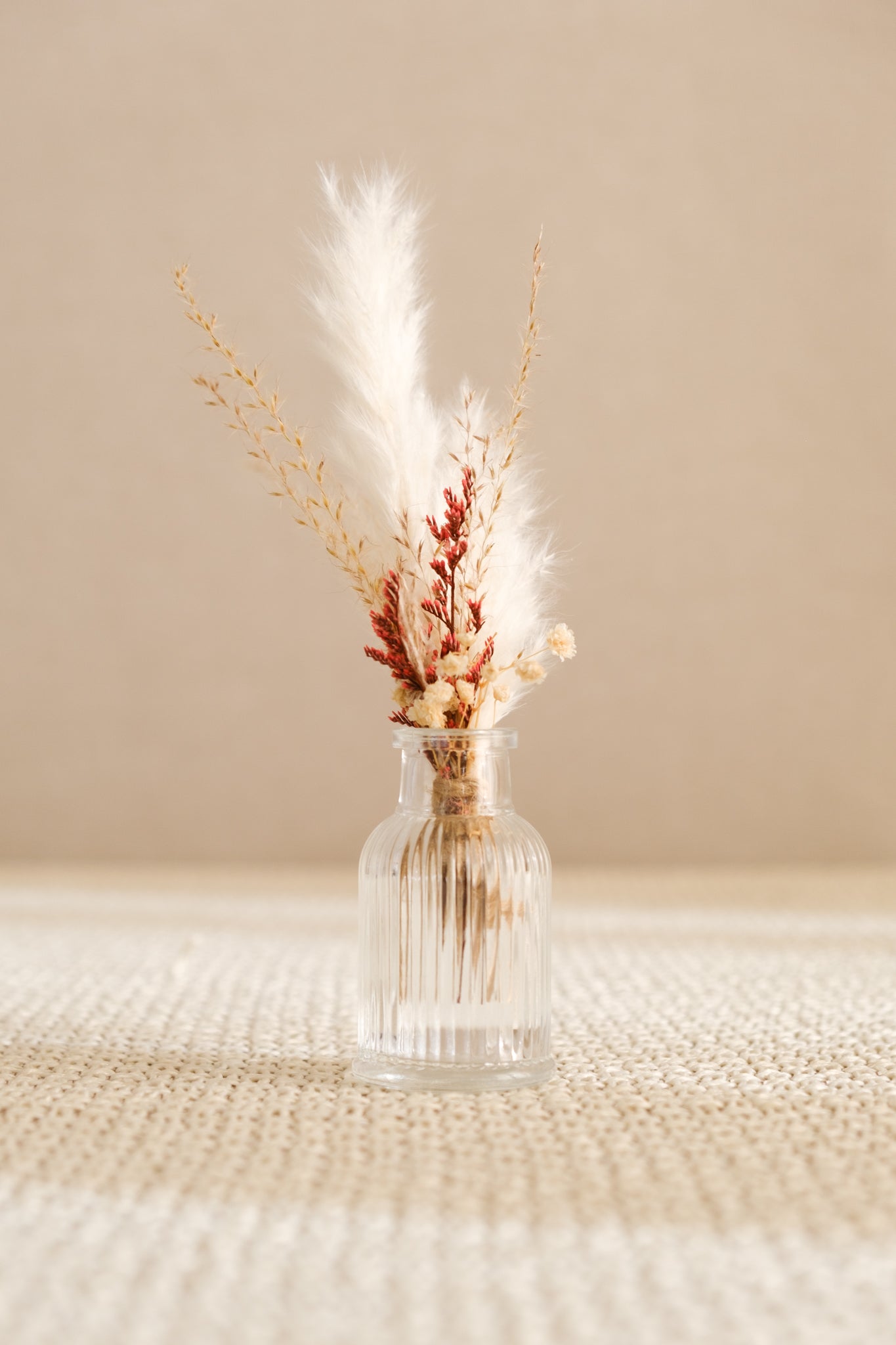 Fiole avec bouquet de fleurs séchées