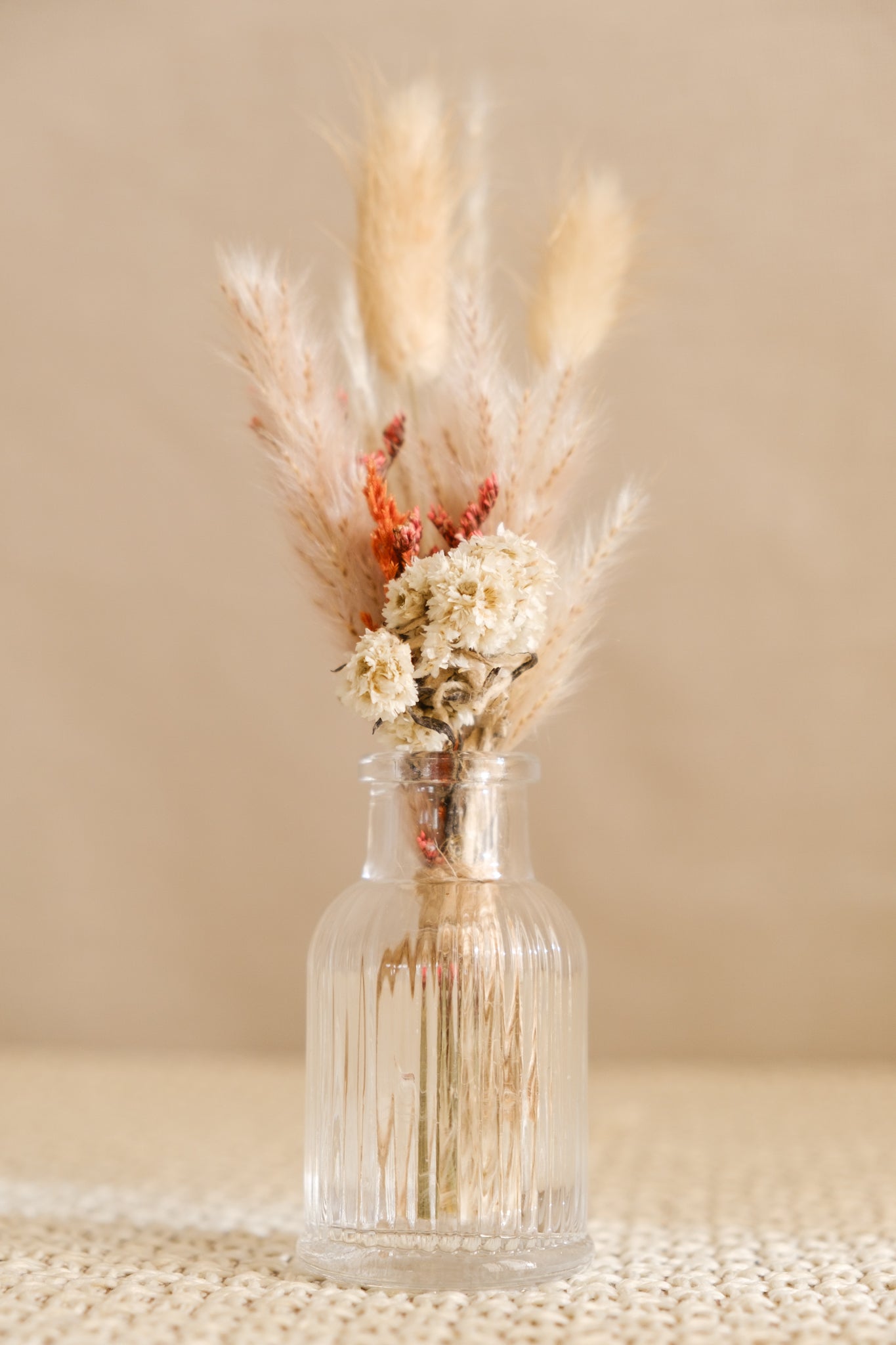 Fiole avec bouquet de fleurs séchées